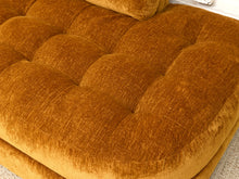 Load image into Gallery viewer, Close-up of a tufted velvet ottoman in a warm camel brown color, showing the textured fabric and button tufting details.
