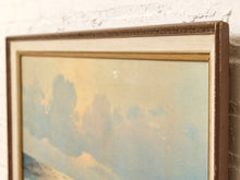 Load image into Gallery viewer, A close-up of a framed landscape painting showing a soft blue sky with clouds and a warm yellow glow, set in a brown frame against a white brick wall.
