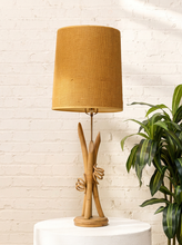 Load image into Gallery viewer, Vintage table lamp with sculptural curved wood base and tall brown woven-texture shade illuminated with a warm glow
