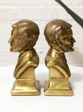 Load image into Gallery viewer, Pair of vintage brass Abraham Lincoln bust bookends with detailed profiles, period clothing, warm patina, and stepped bases
