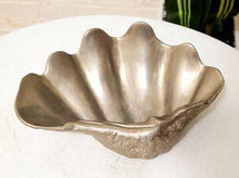 Load image into Gallery viewer, A vintage metallic silver shell-shaped bowl with a textured, scalloped rim, displayed on a white fabric-covered surface.
