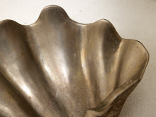 Load image into Gallery viewer, A close-up of a metallic shell-shaped dish or bowl with a scalloped rim, showing a brushed silver and bronze finish against a light neutral background.
