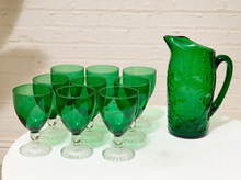 Load image into Gallery viewer, Vintage emerald green glassware set with green goblets on clear textured pedestal stems and coordinating handled green glass pitcher
