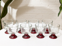 Load image into Gallery viewer, Set of eight vintage smoky clear glass tumblers with rounded bowls and contrasting ruby red pedestal bases
