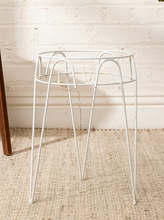 Load image into Gallery viewer, Vintage white painted metal plant stand with open circular wire frame, curved decorative supports, and four slender legs
