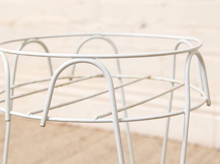 Load image into Gallery viewer, Vintage white painted metal plant stand with open circular wire frame, curved decorative supports, and four slender legs
