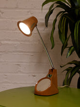 Load image into Gallery viewer, Vintage 1970s orange Space Age desk lamp with chrome adjustable stem, flared shade and circular mirror built into the base.
