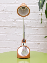 Load image into Gallery viewer, Vintage 1970s orange Space Age desk lamp with chrome adjustable stem, flared shade and circular mirror built into the base.
