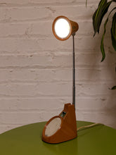 Load image into Gallery viewer, Vintage 1970s orange Space Age desk lamp with chrome adjustable stem, flared shade and circular mirror built into the base.
