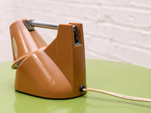 Load image into Gallery viewer, Rear view of the orange desk lamp folded down, showing the base, retracted chrome stem and power cord.
