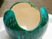Load image into Gallery viewer, A close-up of a ceramic bowl with a glossy teal and green marbled exterior and a smooth, warm beige interior, resting on a white surface.
