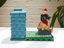 Load image into Gallery viewer, Vintage cast iron artillery bank with standing soldier, cannon, green textured fort, and colorful painted details
