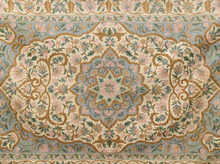 Load image into Gallery viewer, An ornate traditional area rug featuring a central medallion and scrolling floral motifs in soft pastel tones of pink, beige, light blue, and sage green.

