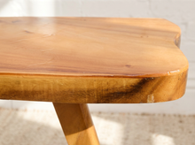 Load image into Gallery viewer, Vintage live edge wood side table with irregular natural wood tabletop, honey-brown grain, visible knots, and three tapered wooden legs
