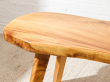 Load image into Gallery viewer, Vintage live edge wood side table with irregular natural wood tabletop, honey-brown grain, visible knots, and three tapered wooden legs
