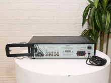 Load image into Gallery viewer, Vintage black Optimus AM/FM stereo receiver with rectangular digital tuner display, large volume knob, front control buttons, and vented top panel

