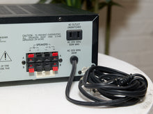 Load image into Gallery viewer, Vintage black Optimus AM/FM stereo receiver with rectangular digital tuner display, large volume knob, front control buttons, and vented top panel

