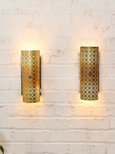 Load image into Gallery viewer, Pair of vintage 1960s metal wall sconces with curved half-cylinder shades, repeating geometric cutout patterns, and rectangular wall mounts
