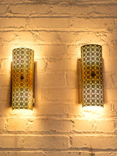 Load image into Gallery viewer, Pair of vintage 1960s metal wall sconces with curved half-cylinder shades, repeating geometric cutout patterns, and rectangular wall mounts
