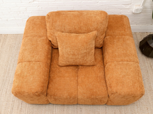 Load image into Gallery viewer, Felipe modern lounge chair in warm terracotta textured upholstery with deep channel-tufted seat, oversized padded arms, rounded silhouette, and coordinating cushions
