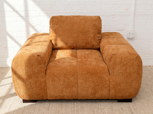 Load image into Gallery viewer, Felipe modern lounge chair in warm terracotta textured upholstery with deep channel-tufted seat, oversized padded arms, rounded silhouette, and coordinating cushions

