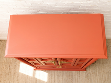Load image into Gallery viewer, Vintage deep red painted armoire with double cabinet doors, ornate gold-tone handles, carved spiral side columns, raised decorative panels, and two lower drawers
