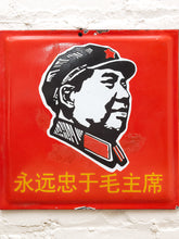 Load image into Gallery viewer, A square red metal sign featuring a black-and-white illustrated portrait of Mao Zedong with a red star on his cap, plus yellow Chinese text at the bottom, mounted against a white brick wall.
