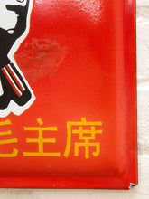 Load image into Gallery viewer, A close-up of a red enamel sign featuring yellow Chinese characters and part of a black-and-white emblem on the left, photographed against a light textured background.
