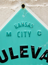 Load image into Gallery viewer, A close-up of a vintage turquoise and black metal street sign for Kansas City, showing the embossed text 'KANSAS M CITY O' and bold black lettering on a white background.
