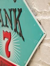 Load image into Gallery viewer, A close-up of a vintage-style turquoise sign with black lettering and a red number 7 on a white brick wall.
