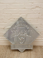 Load image into Gallery viewer, Vintage metal sign for Tropicana Cafe on Boulevard in San Francisco, featuring an embossed silver metal diamond shape with a base plaque, displayed against a white brick wall and burlap floor.
