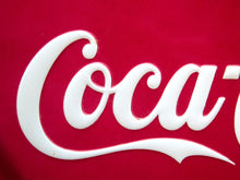 Load image into Gallery viewer, Close-up of the white Coca-Cola script logo on a red background.

