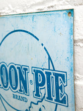 Load image into Gallery viewer, Vintage-style Moon Pie metal advertising sign with distressed cream background, large blue Moon Pie logo, circular graphic, and The Biggest and Best Lunch in Town for 5¢ slogan

