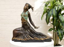 Load image into Gallery viewer, Art Deco bronze dancer sculpture in the style of Dimitri Chiparus depicting Clara in a seated pose with an elaborate headdress, turquoise patinated bodice, gold-tone decorative accents, and a flowing bronze skirt.
