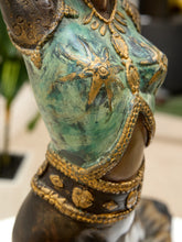 Load image into Gallery viewer, Close-up of a decorative sculpture or figurine showing a torso with a distressed turquoise and green patina finish, gold-toned star and floral motifs, and dark brown metallic sections.
