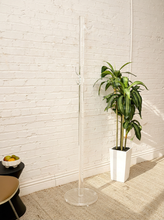 Load image into Gallery viewer, Vintage freestanding clear Lucite coat rack featuring a tall transparent cylindrical column, curved transparent hooks at different heights, and a round clear base.
