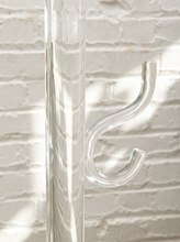 Load image into Gallery viewer, Vintage freestanding clear Lucite coat rack featuring a tall transparent cylindrical column, curved transparent hooks at different heights, and a round clear base.

