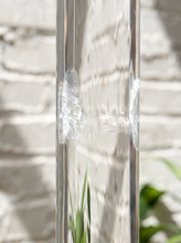 Load image into Gallery viewer, Vintage freestanding clear Lucite coat rack featuring a tall transparent cylindrical column, curved transparent hooks at different heights, and a round clear base.
