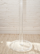 Load image into Gallery viewer, Vintage freestanding clear Lucite coat rack featuring a tall transparent cylindrical column, curved transparent hooks at different heights, and a round clear base.
