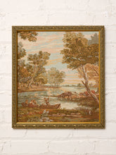 Load image into Gallery viewer, Vintage framed pastoral landscape tapestry depicting a peaceful river with grazing cattle, figures in a small boat, tall leafy trees, and a soft pink and peach sky, displayed in an ornate gold-tone frame.
