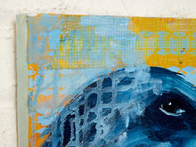 Load image into Gallery viewer, Close-up of an abstract painting featuring a blue fish head with textured brushstrokes, layered over yellow and light blue patterns, shown against a white wall.

