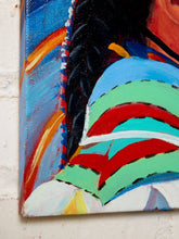 Load image into Gallery viewer, Close-up of a colorful painted canvas showing a stylized figure with dark hair, blue, green, red, and white brushstrokes, photographed against a light textured wall.
