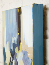 Load image into Gallery viewer, An abstract canvas painting with textured brushstrokes in blue, white, beige, yellow, and dark navy, shown at an angle against a light brick wall.
