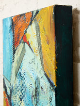 Load image into Gallery viewer, Image 6 of 8: Abstract canvas wall art with thick textured brushstrokes in blue, yellow, orange, white, and dark green, shown hanging against a light brick wall.
