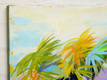 Load image into Gallery viewer, Abstract canvas painting of tropical palm leaves in vibrant green, yellow, orange, and blue against a soft cream and light blue sky background, shown hanging on a white textured wall.
