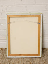 Load image into Gallery viewer, The back view of a vintage framed picture frame, featuring a light natural wood inner border, a distressed off-white outer frame, and a metal hanging wire with clips, set against a white brick wall and woven rug.
