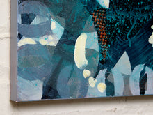 Load image into Gallery viewer, Abstract canvas wall art featuring textured brushstrokes and splatter details in shades of teal, blue, gray, white, and small rust-orange accents, shown hanging against a white brick wall.
