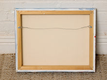 Load image into Gallery viewer, The back view of a framed canvas print, showing a light natural wood frame, a beige linen backing, and a wire hanging system, set against a white brick wall and woven rug.
