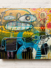 Load image into Gallery viewer, A colorful abstract painting on canvas mounted on a white textured wall. The artwork features expressive cartoon-like figures, bold blue and yellow shapes, a red sun motif, and black linework with layered paint textures.
