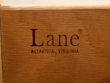 Load image into Gallery viewer, Close-up of a wooden surface with the engraved brand name 'Lane' and 'ALTAVISTA, VIRGINIA' in dark lettering.
